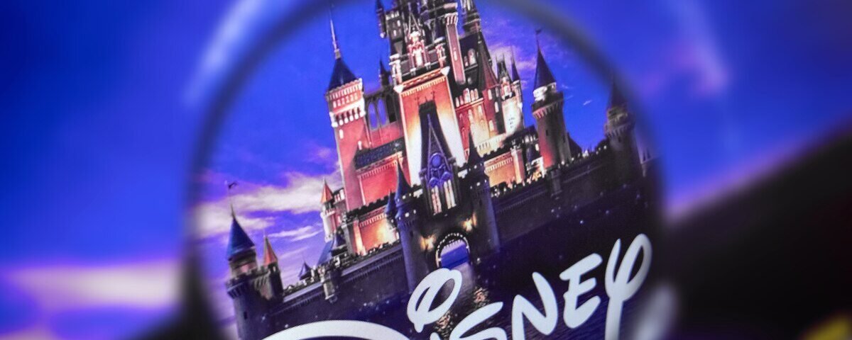Une loupe se concentre sur le logo Disney avec un château en arrière-plan dans un ciel bleu et violet, soulignant la présence emblématique de Disney et ses obligations en 2020.