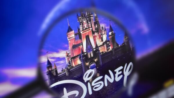 Une loupe se concentre sur le logo Disney avec un château en arrière-plan dans un ciel bleu et violet, soulignant la présence emblématique de Disney et ses obligations en 2020.