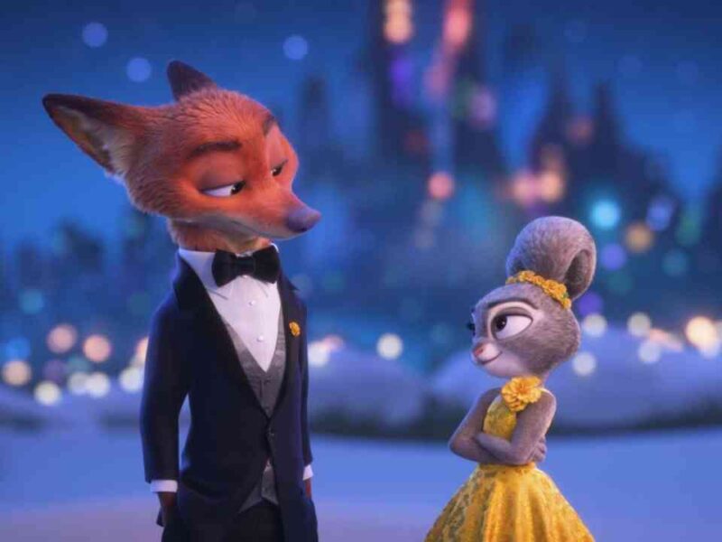 Un renard animé en smoking et un lapin en robe jaune se tiennent côte à côte avec un château flou en arrière-plan la nuit, capturant la magie caractéristique de Disney qui promet une excitation mondiale au box-office pour 2026.