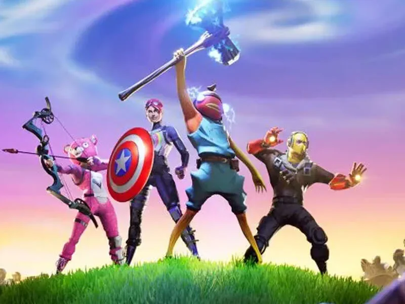 Quatre personnages de Disney X Fortnite en costumes colorés posent héroïquement sur une colline herbeuse, avec pour toile de fond un ciel stylisé et des figures robotiques - une scène épique de l'Univers Révolutionnaire 2027 dans Disney X Fortnite.