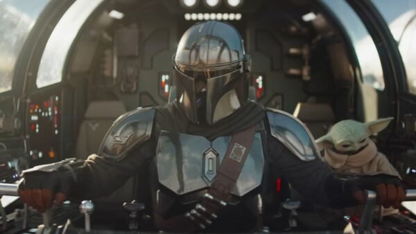 Un Mandalorien en armure métallique pilote un vaisseau spatial, avec Grogu, la petite créature verte, assis à proximité dans le cockpit.