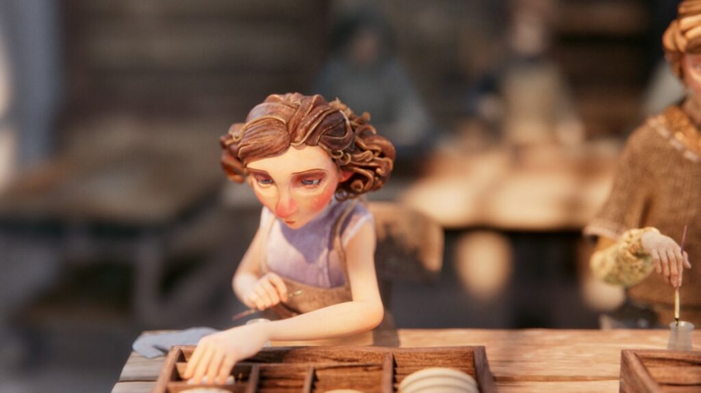 Une femme aux cheveux bruns et au haut violet, assise à une table en bois, semble travailler avec de petits objets dans la charmante tradition de l'animation française.