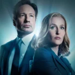 Deux personnes en tenue de travail se tiennent dos à dos avec des expressions sérieuses, éclairées par une lumière bleue provenant de l'arrière, évoquant l'atmosphère mystérieuse de The X-files et rappelant les rôles emblématiques de Gillian Anderson.