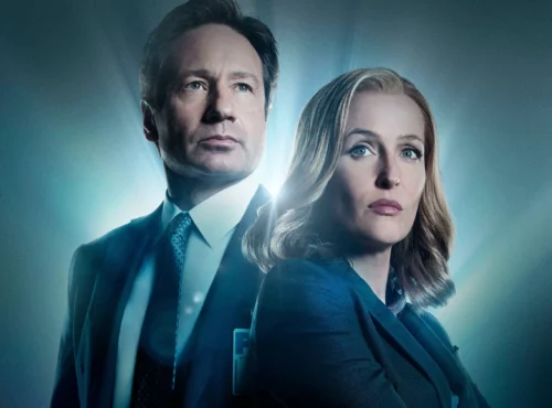 Deux personnes en tenue de travail se tiennent dos à dos avec des expressions sérieuses, éclairées par une lumière bleue provenant de l'arrière, évoquant l'atmosphère mystérieuse de The X-files et rappelant les rôles emblématiques de Gillian Anderson.
