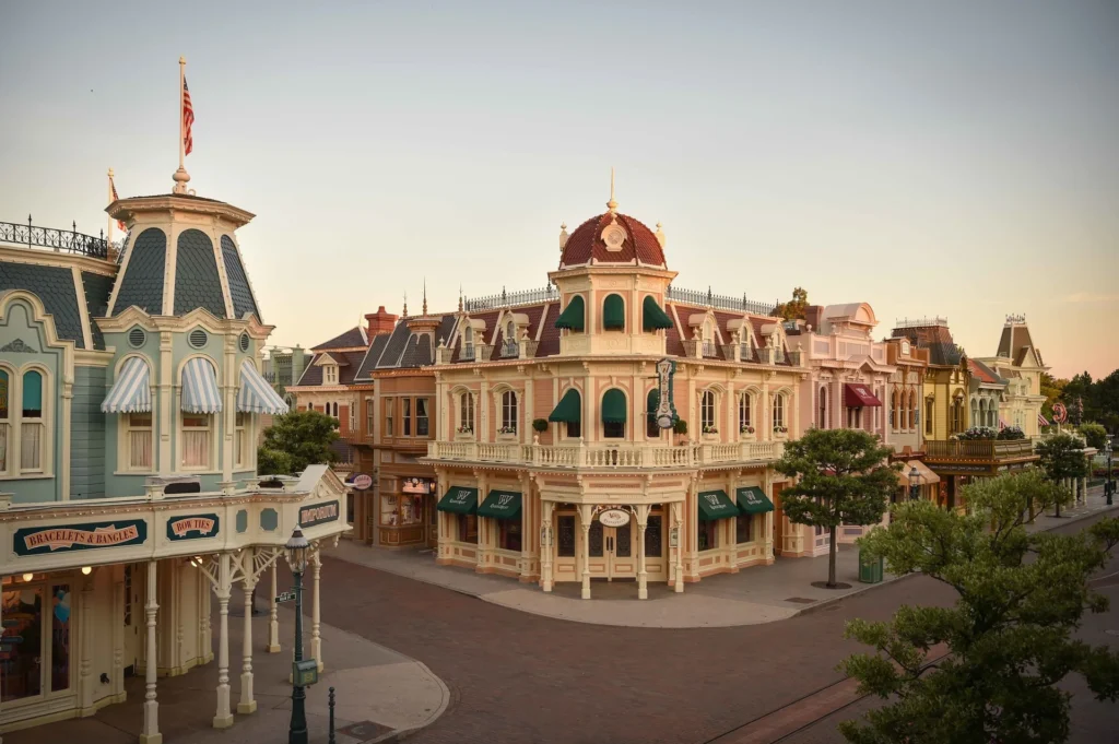 Une Main Street U.S.A. déserte et pittoresque avec des bâtiments colorés de style vintage à l'aube ou au crépuscule à Disneyland Paris, rappelant le charme créé par le designer Eddie Sotto.