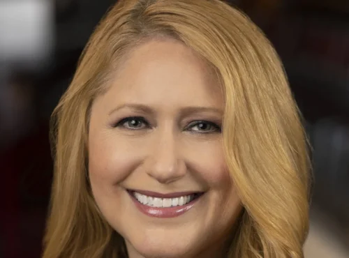 Une femme aux longs cheveux blonds sourit à l'appareil photo dans un portrait en gros plan, reflétant la chaleur et le charme que l'on retrouve souvent dans les émissions de Disney Entertainment Television.