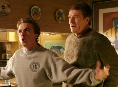 Deux hommes se tiennent dans une cuisine ; le plus jeune, qui ressemble à Malcolm (Frankie Muniz), parle avec emphase, les bras tendus, tandis que le plus âgé, qui ressemble beaucoup au personnage de Bryan Cranston, regarde la scène d'un air inquiet.