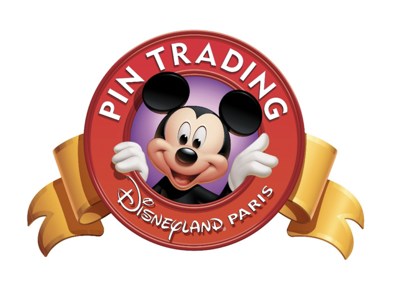 Logo de Disneyland Paris Pin Trading représentant Mickey Mouse souriant et saluant à l'intérieur d'un badge circulaire rouge avec un ruban jaune au bas, commémorant le lancement du pin trading le 6 octobre 2001.
