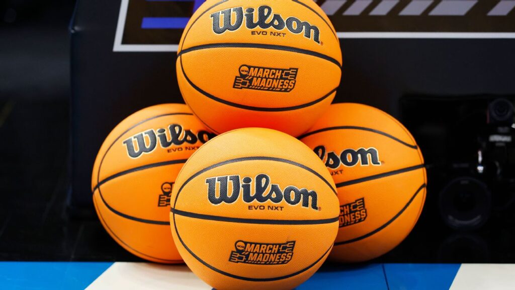 Quatre ballons de basket Wilson EVO NXT avec les logos "March Madness" sont empilés sur un terrain de basket, capturant l'excitation de NCAA 2026 et l'esprit du basket américain pendant la saison des tournois.