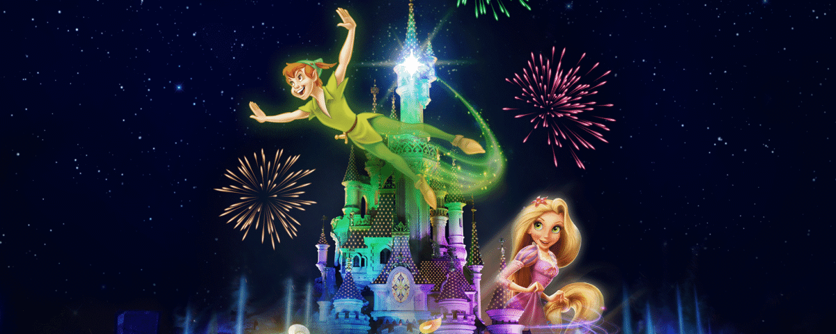 Les personnages animés de Disney, Peter Pan, Clochette, Raiponce et Lumière, apparaissent au-dessus du château de Disneyland Paris illuminé par des feux d'artifice et des fontaines la nuit.