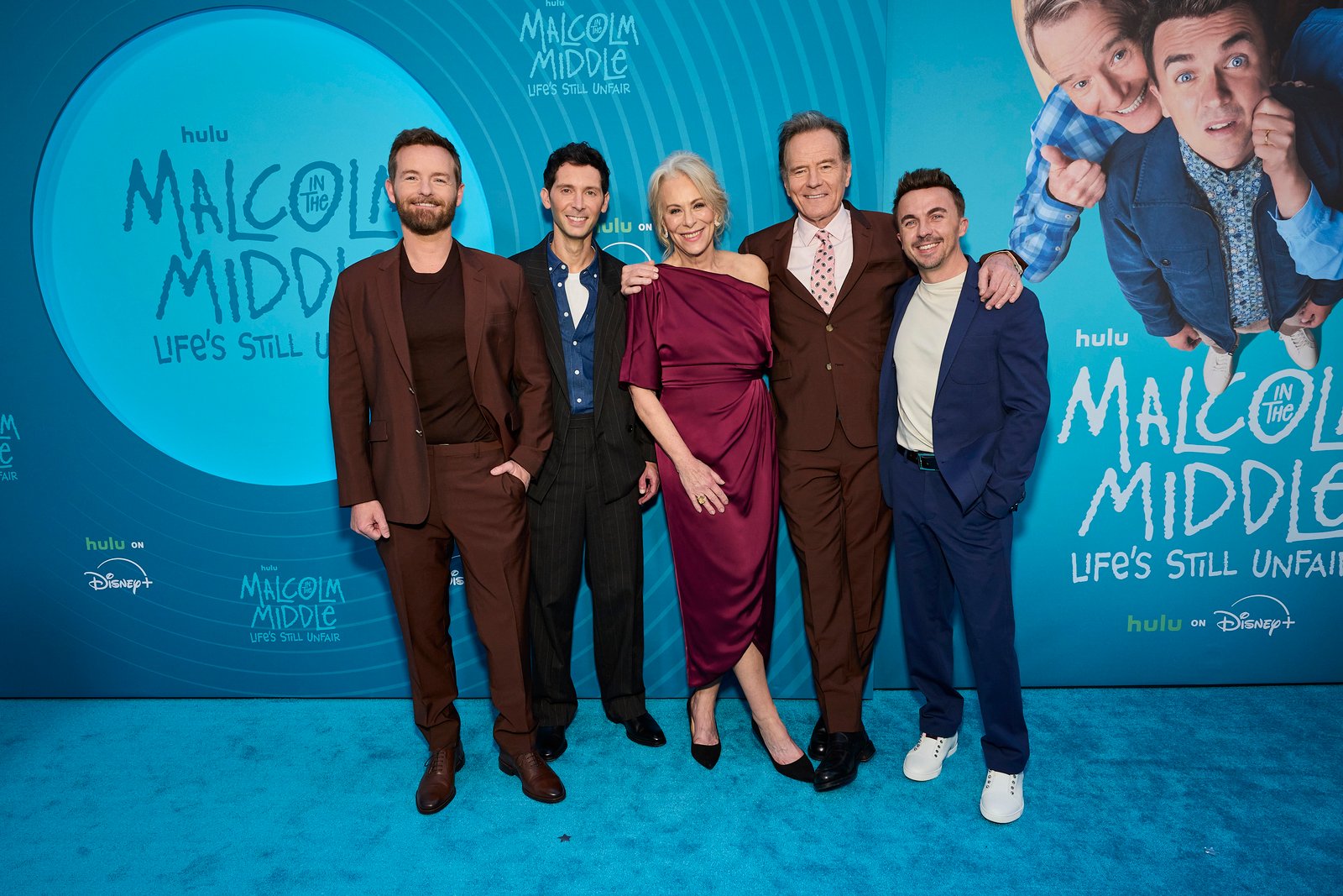 Cinq personnes se tiennent ensemble sur un tapis bleu lors de l'avant-première new-yorkaise de "Malcolm in the Middle : Life's Still Unfair", qui célèbre le grand retour de Malcolm lors d'une réunion spéciale sur Hulu.