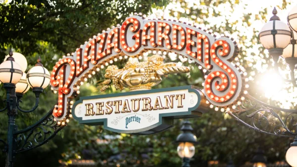 Le panneau d'entrée du restaurant Plaza Gardens, comportant des lettres lumineuses et entouré de lampadaires décoratifs et de verdure, annonce la rénovation du restaurant et indique qu'il sera fermé en 2027.