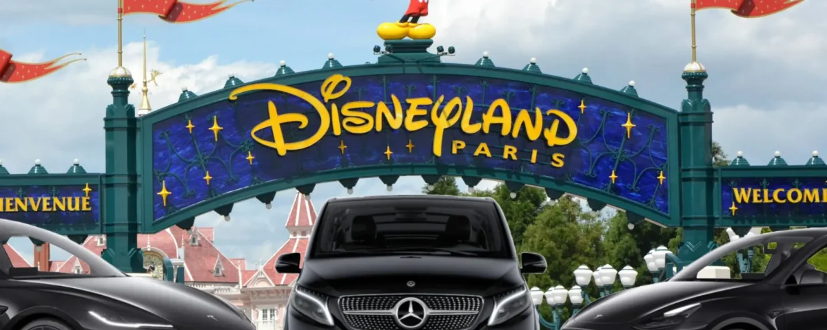 Entrée de Disneyland Paris avec une statue de Mickey Mouse au-dessus du panneau et trois voitures noires, dont un taxi Mercedes. Pour les personnes intéressées par le tarif taxi Disneyland, ces taxis offrent un transport pratique jusqu'à l'entrée du parc.