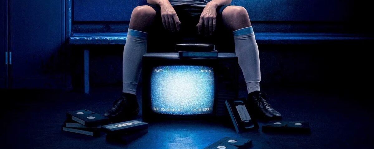 Une personne en tenue de sport est assise sur un banc derrière un vieux téléviseur affichant des parasites, entourée de cassettes VHS éparpillées sur le sol, dont une étiquetée "The Forgotten Tape" (la cassette oubliée) montrant un jeune Lionel Messi.