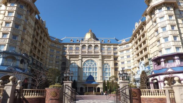 Un grand hôtel à l'architecture somptueuse, avec un dôme central et des portails décorés, sous un ciel d'un bleu limpide : le meilleur endroit où séjourner près de Tokyo Disneyland pour vivre une expérience inoubliable.