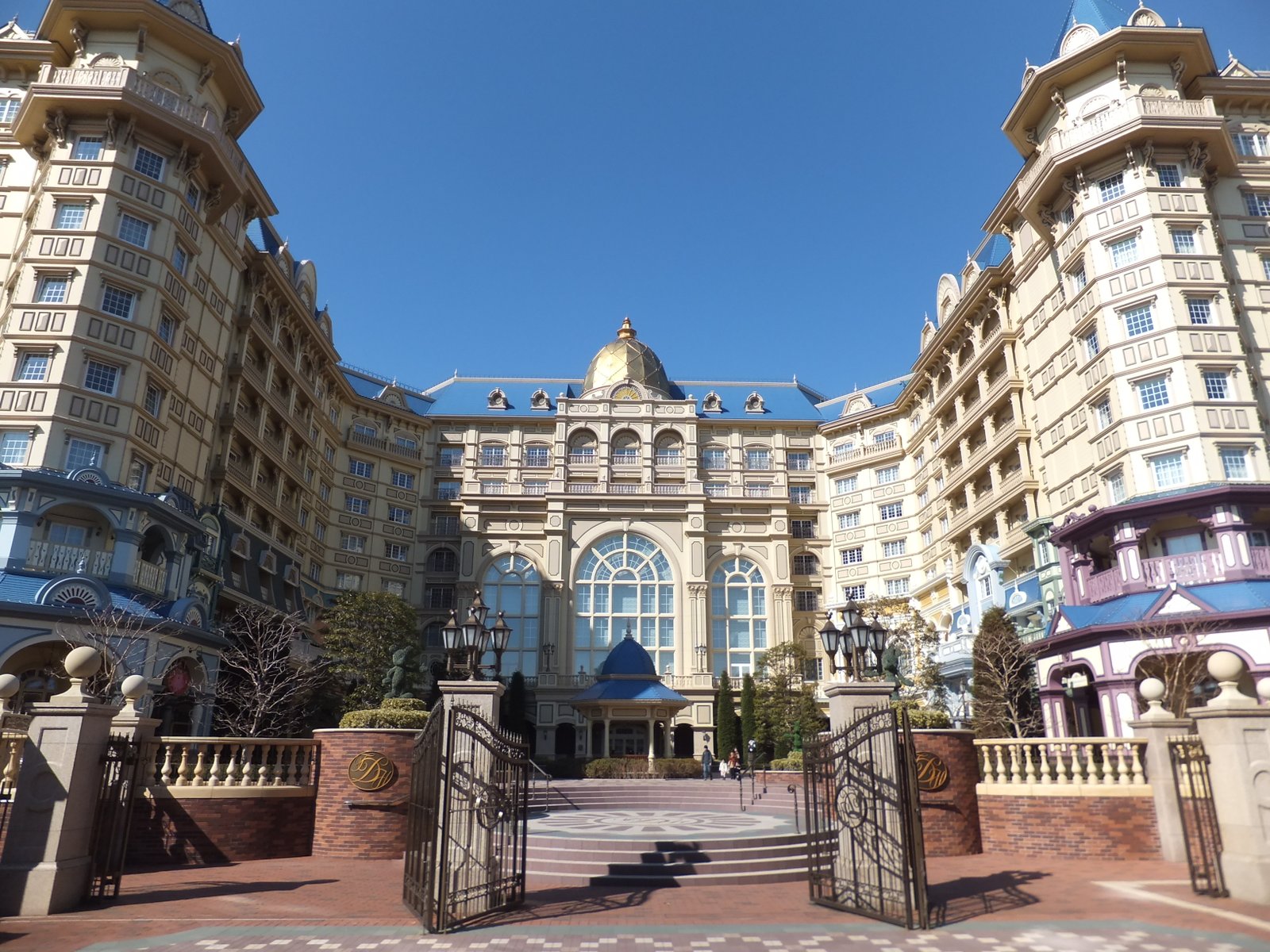 Un grand hôtel à l'architecture somptueuse, avec un dôme central et des portails décorés, sous un ciel d'un bleu limpide : le meilleur endroit où séjourner près de Tokyo Disneyland pour vivre une expérience inoubliable.