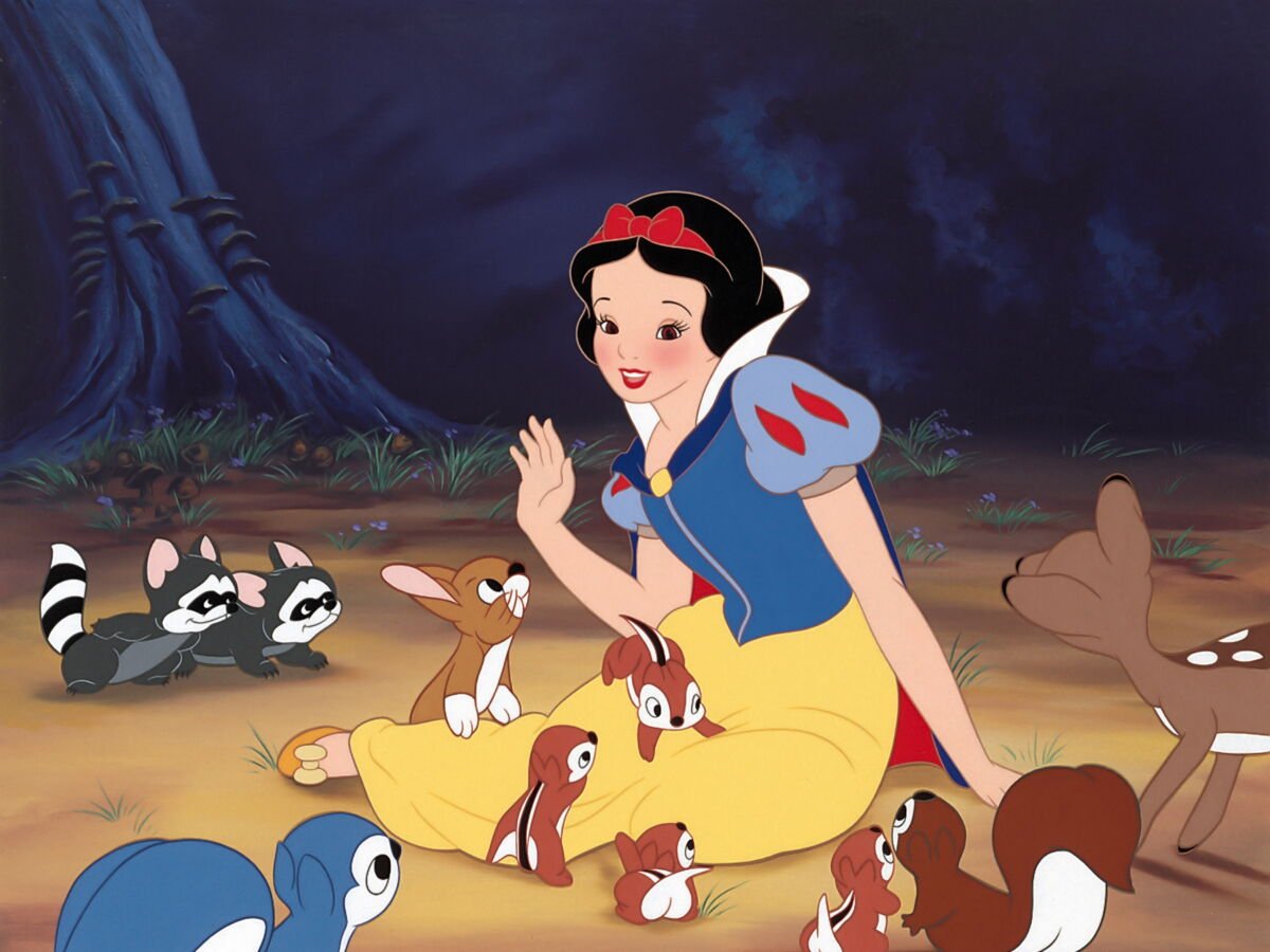 Une femme animée, vêtue d'une robe jaune et bleue, est assise par terre dans une forêt, entourée de lapins, de cerfs, de ratons laveurs et d'oiseaux - une scène qui rappelle un film de Disney populaire.