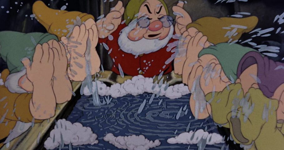 Des nains animés s'aspergent le visage et les pieds d'eau au-dessus d'un bac en bois, créant des ondulations et de la mousse, tout en chantant joyeusement l'hymne « Bluddle-Uddle-Um-Dum ».