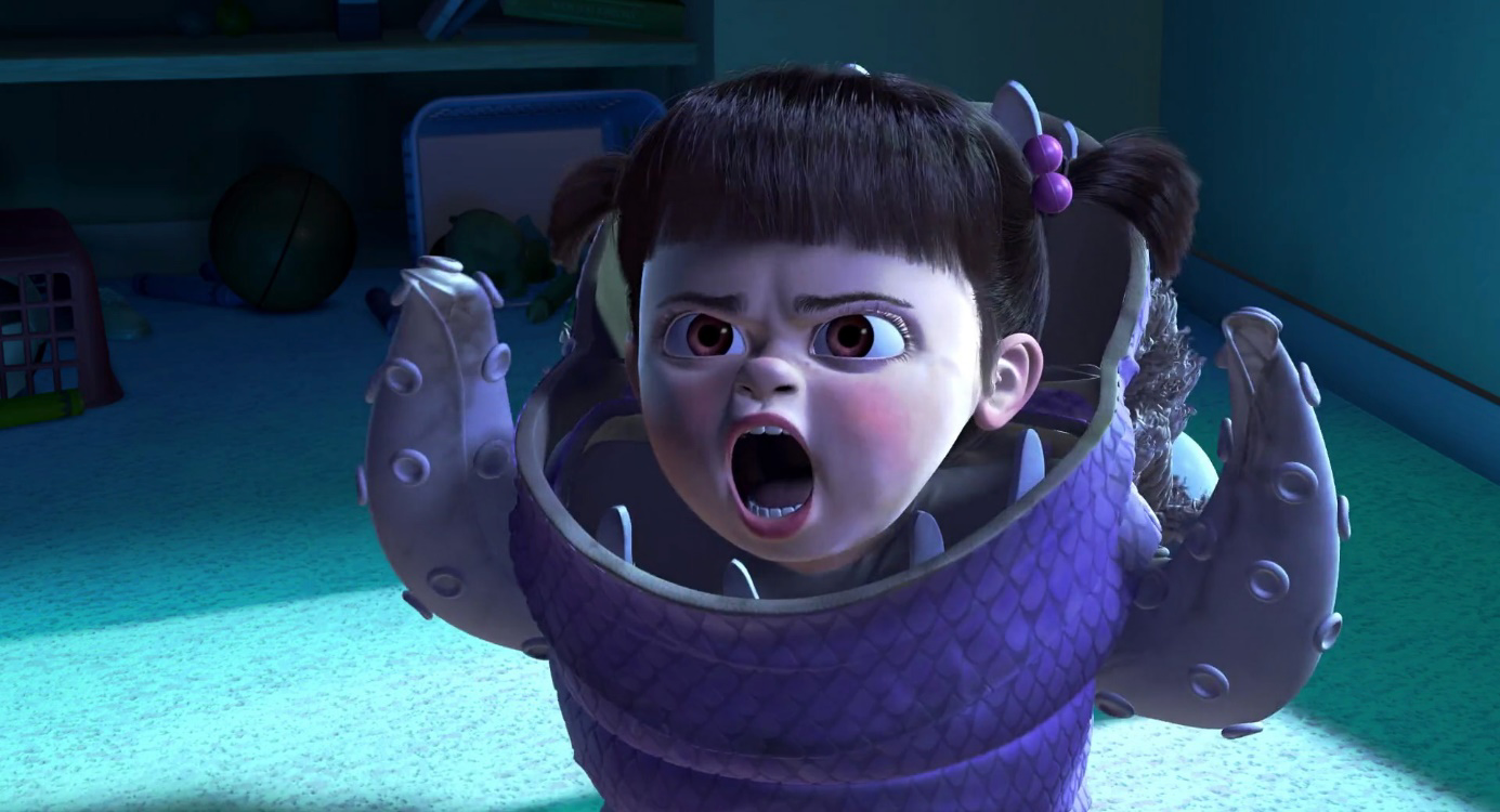 Une petite fille vêtue d'un costume violet de monstre « Monstres et Cie » lève les bras et crie, debout dans une pièce faiblement éclairée avec des jouets en arrière-plan, qui rappelle l'univers magique dévoilé lors de la sortie du film, le 2 novembre 2001.