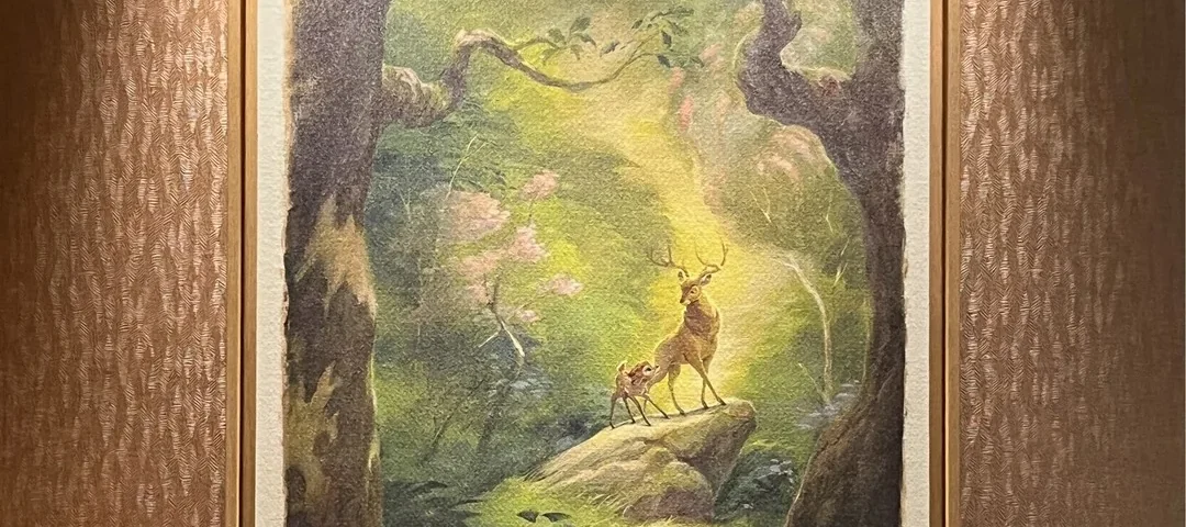 Tableau encadré représentant un cerf et son faon debout sur un rocher dans une forêt baignée de soleil, qui rappelle les « tableaux exclusifs » que l'on trouve dans les « chambres rénovées » du Disney Sequoia Lodge, accroché sur un mur à motifs sous des spots.