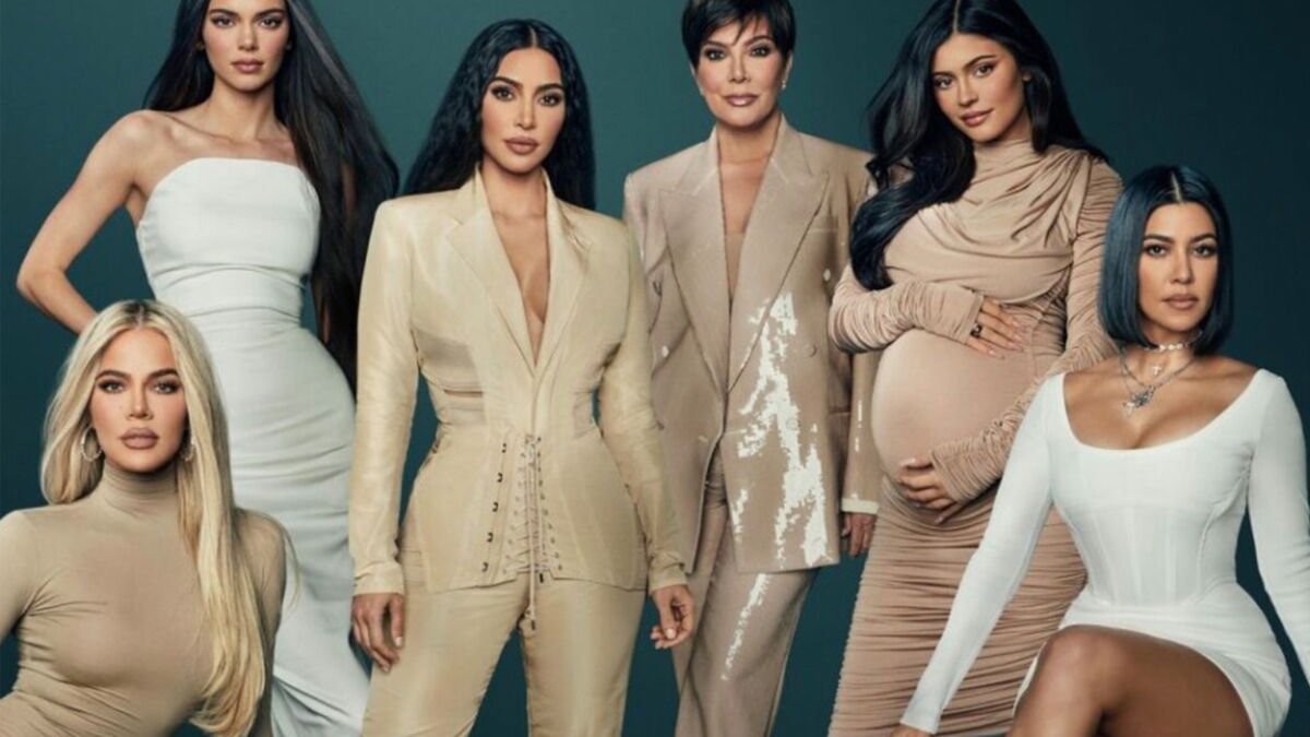 Six femmes posent ensemble sur un fond sombre, vêtues de tenues neutres assorties, dont l'une est visiblement enceinte — une scène qui rappelle la famille Kardashian telle qu'on la voit dans la saison 8, désormais disponible en streaming sur Disney+.