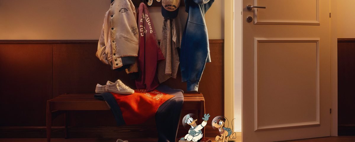 Un banc en bois sur lequel sont posés des vestes, un chapeau et des baskets Golden Goose, avec des personnages de Mickey et ses amis superposés à la scène.