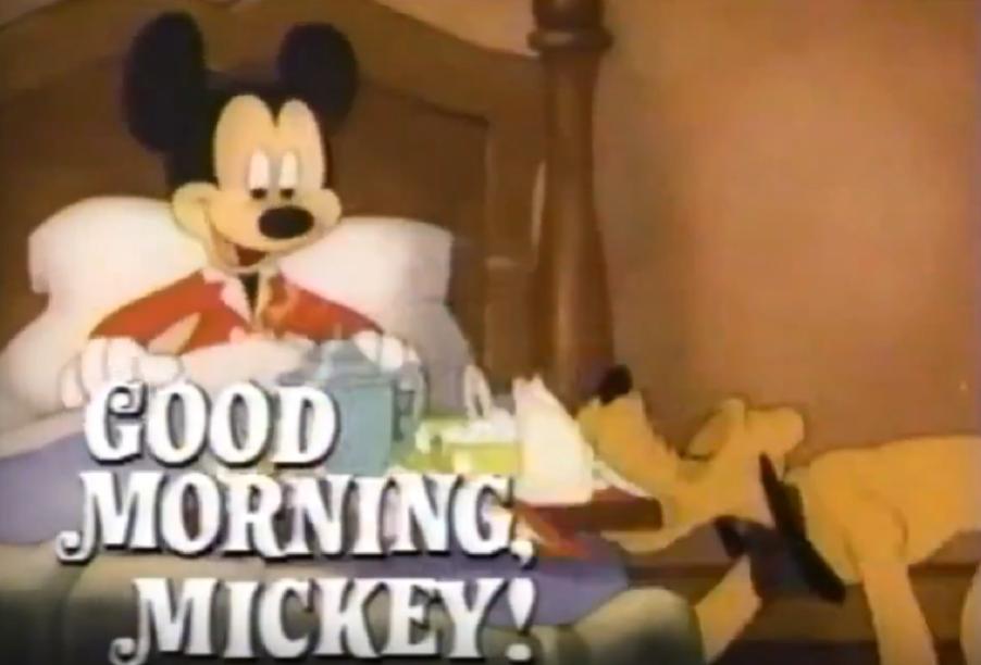 Mickey Mouse est assis dans son lit, un plateau avec son petit-déjeuner à la main, tandis que Pluto se tient à ses côtés. On peut lire : « BONJOUR, MICKEY ! » — exactement comme lors du lancement de Disney Channel, le 18 avril 1983.